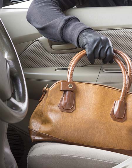Image of purse being stolen from a vehicle.